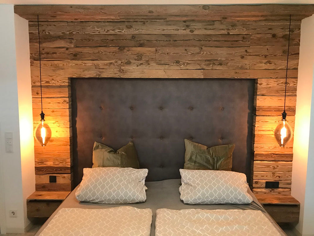 Hand-hewn reclaimed wood boards used as a rustic bedroom wall feature