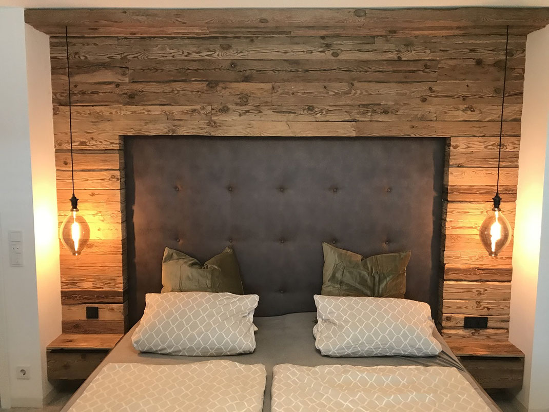Hand-hewn reclaimed wood boards used as a rustic bedroom wall feature