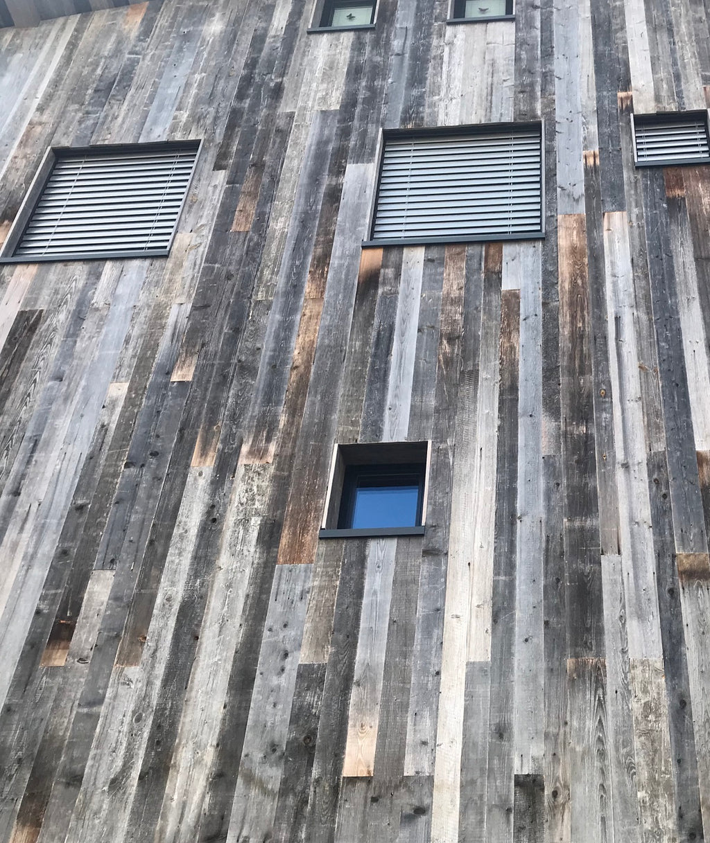 Sunburnt grey reclaimed wood tongue and groove boards used as façade cladding