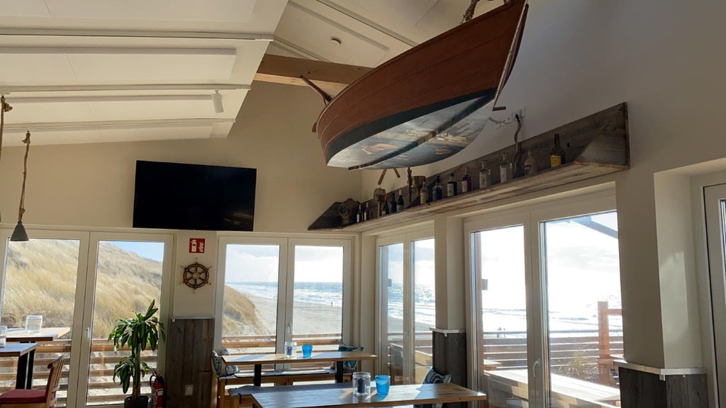 Sunburnt grey reclaimed wood wall cladding in a coastal restaurant interior