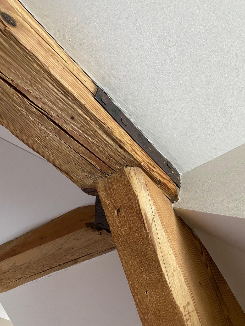 Massive hand-hewn reclaimed wood beams used as ceiling beams in a living space