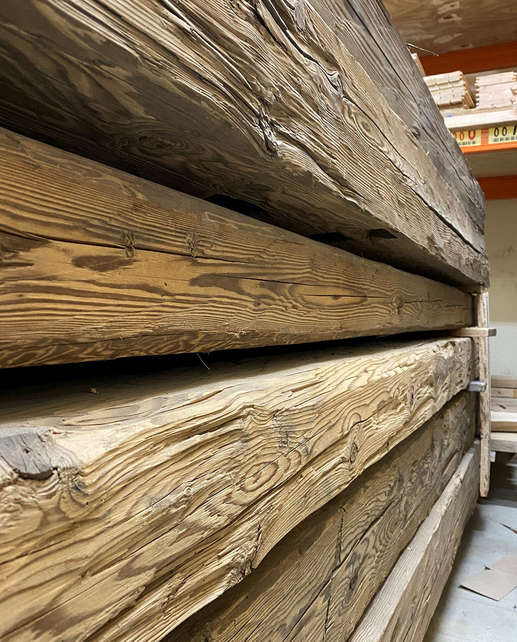 Close-up of a hand-hewn reclaimed timber beam with visible historic tool marks