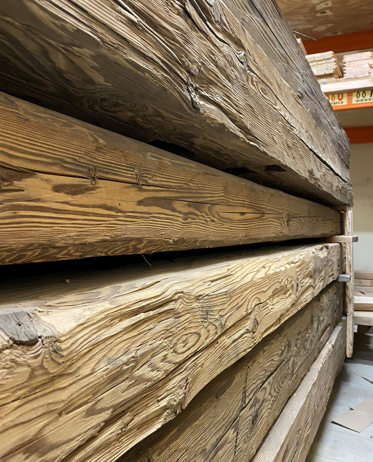 Close-up of a hand-hewn reclaimed timber beam with visible historic tool marks