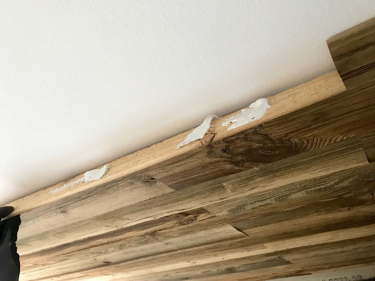 Installation of Vario Brown reclaimed wood wall panels with mounting adhesive