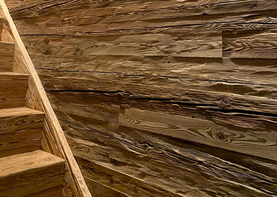 Feature wall with hand-hewn reclaimed wood boards by Vintage Holz