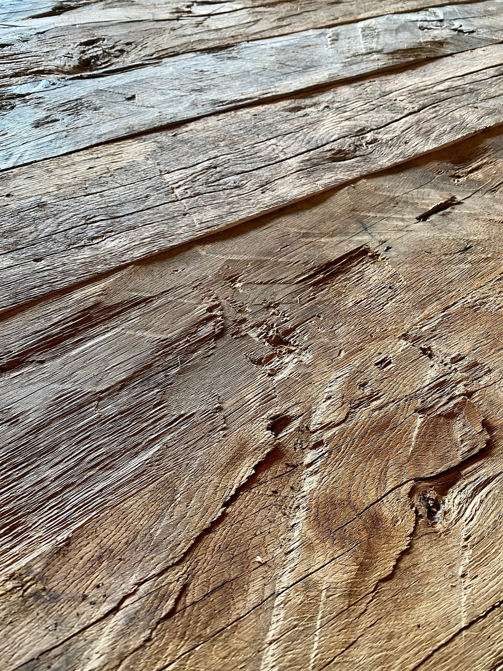 Close-up of hand-hewn reclaimed oak surface with grain and axe marks