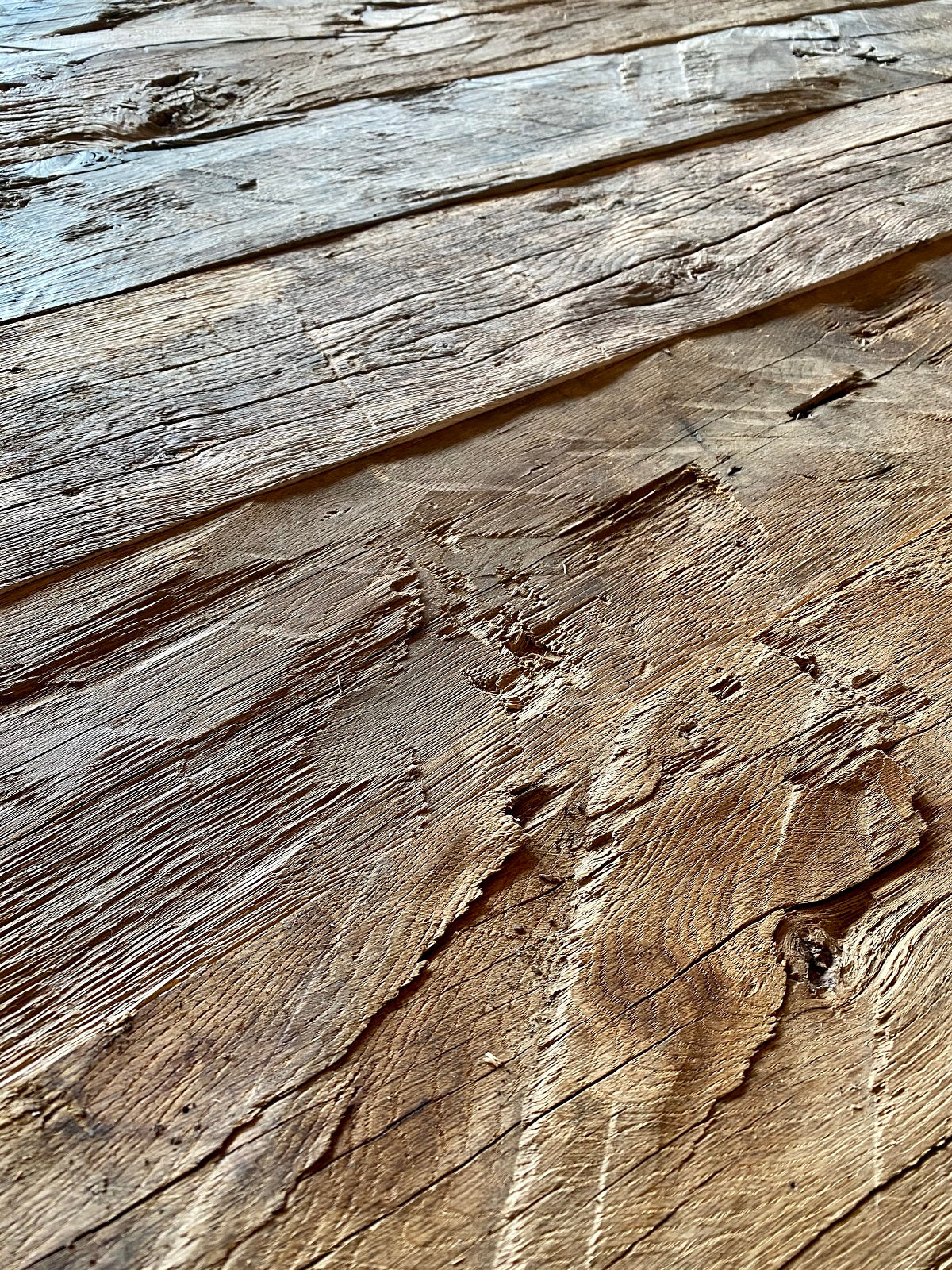 Close-up of hand-hewn reclaimed oak surface with grain and axe marks