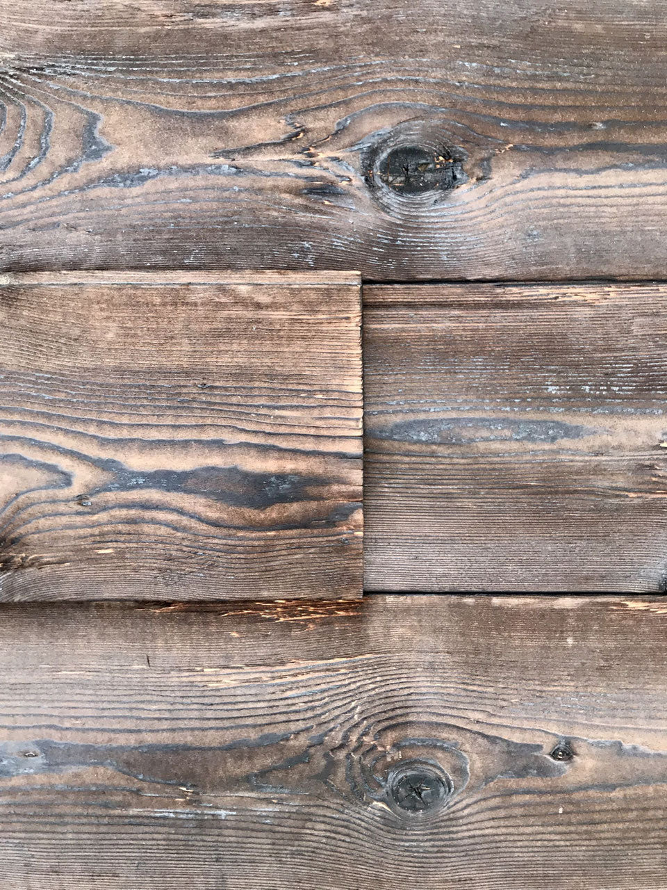 Burnt spruce tongue and groove wall cladding with rustic hewn surface