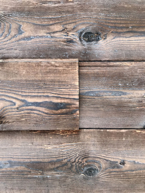 Burnt spruce tongue and groove wall cladding with rustic hewn surface