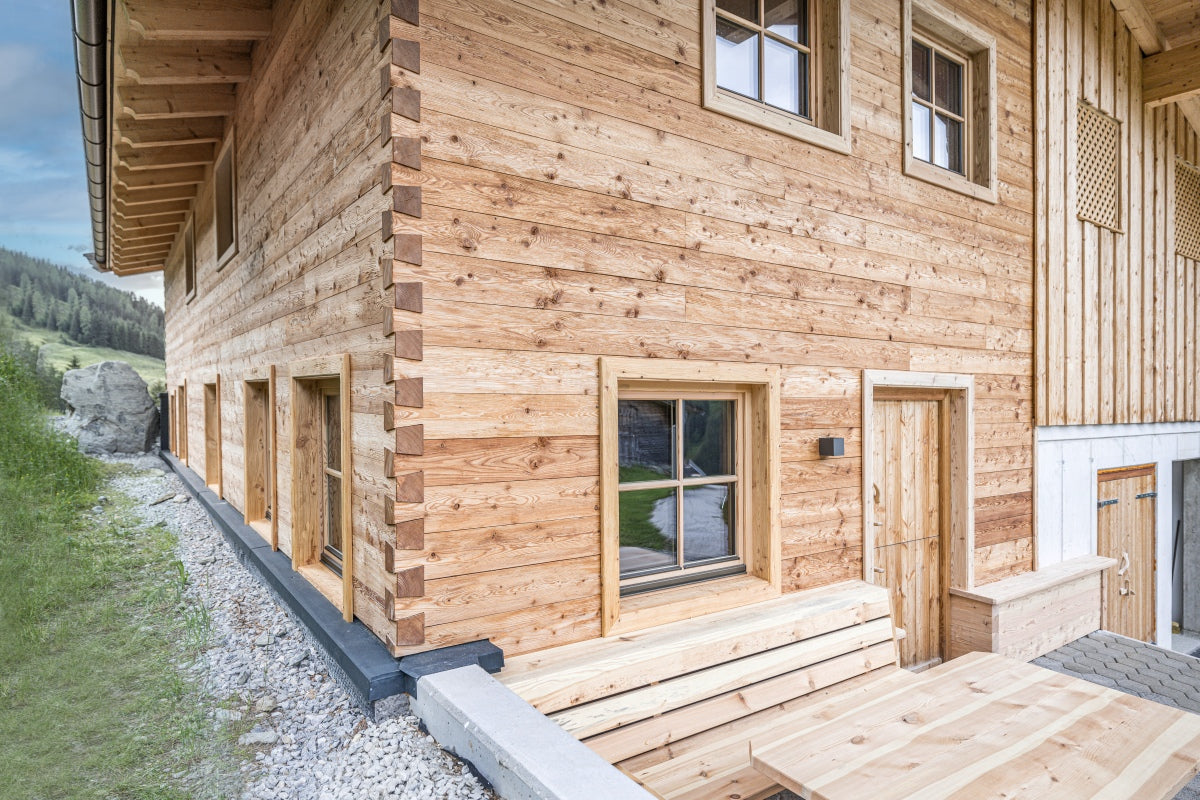Exterior facade clad with hewn and brushed larch boards