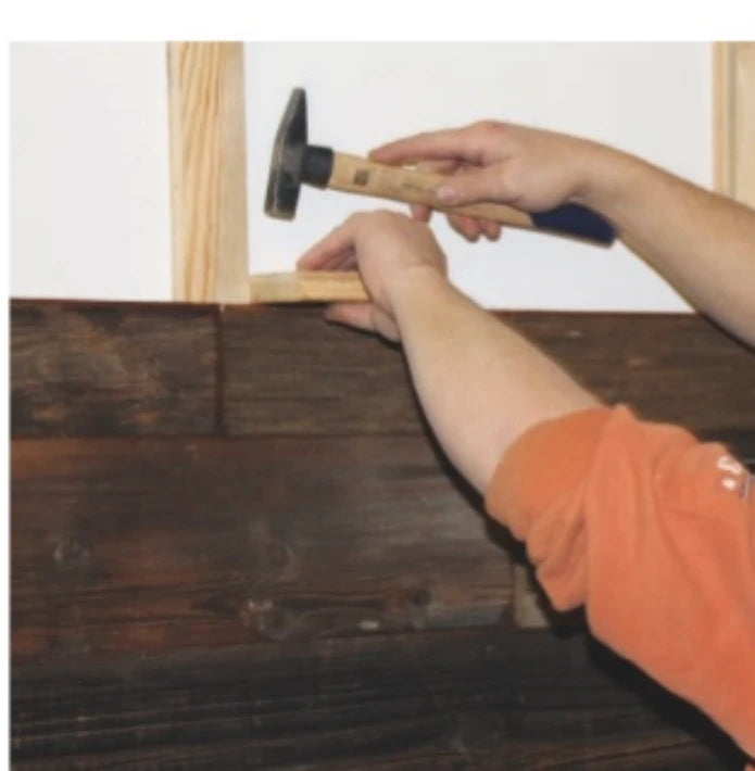 Sorgfältiges Schließen der Nut-und-Feder-Verbindungen mit Holzklotz und Hammer