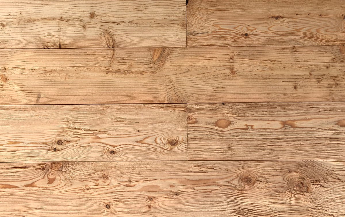 Rustic wall cladding made from hewn and brushed larch boards